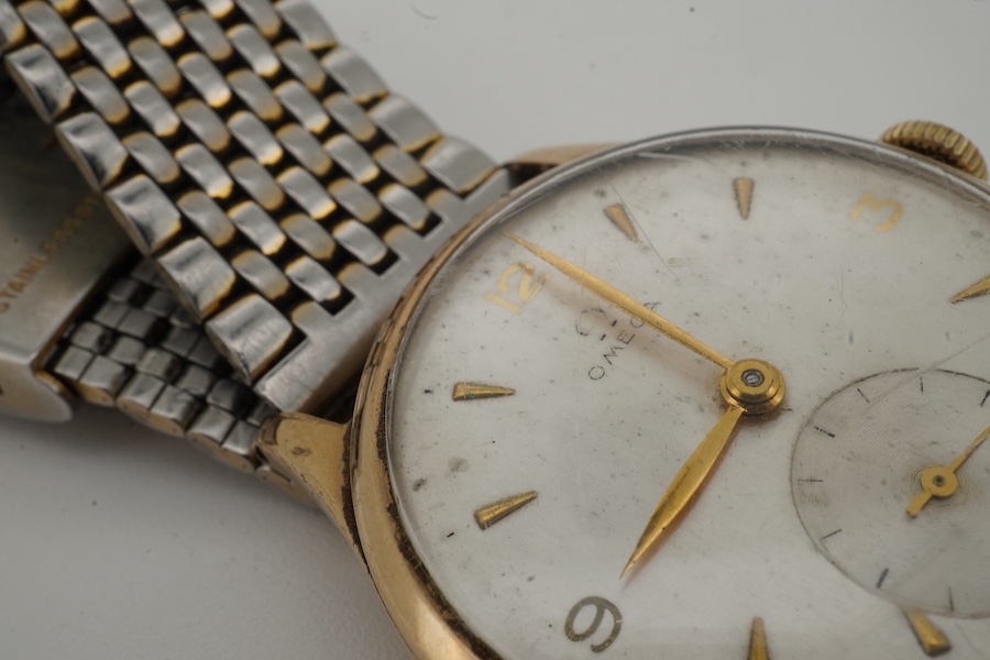 A gentleman's late 1940's 9ct gold Omega manual wind wrist watch, with baton and quarterly Arabic numerals and subsidiary seconds, movement c.265, case diameter 33mm, no logo on winding crown, on an associated stainless